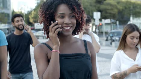 Smiling-young-woman-talking-on-smartphone